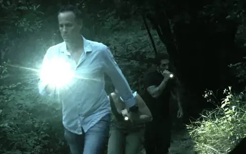 Agents with torches in the forest at night