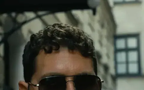 Man in sunglasses in front of an old building