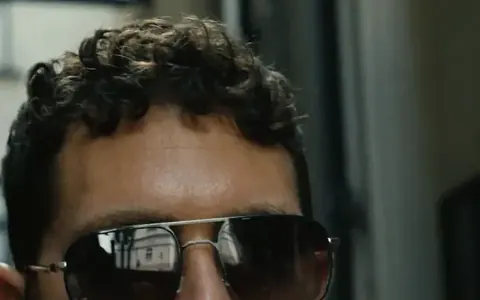 Man in sunglasses, his face half hidden