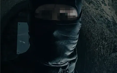 Masked figure in the shadows