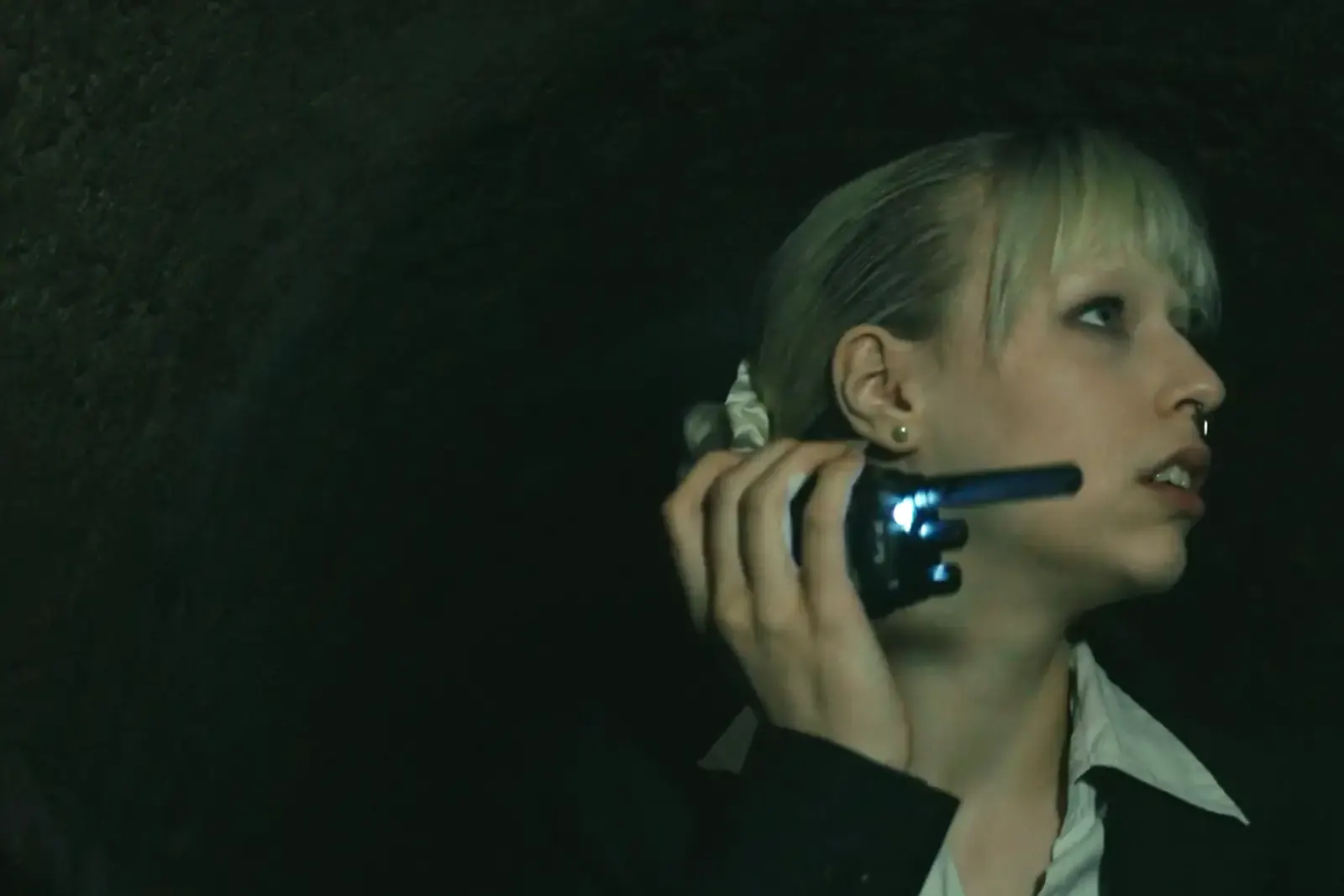 An agent with a radio in a dark vaulted cellar