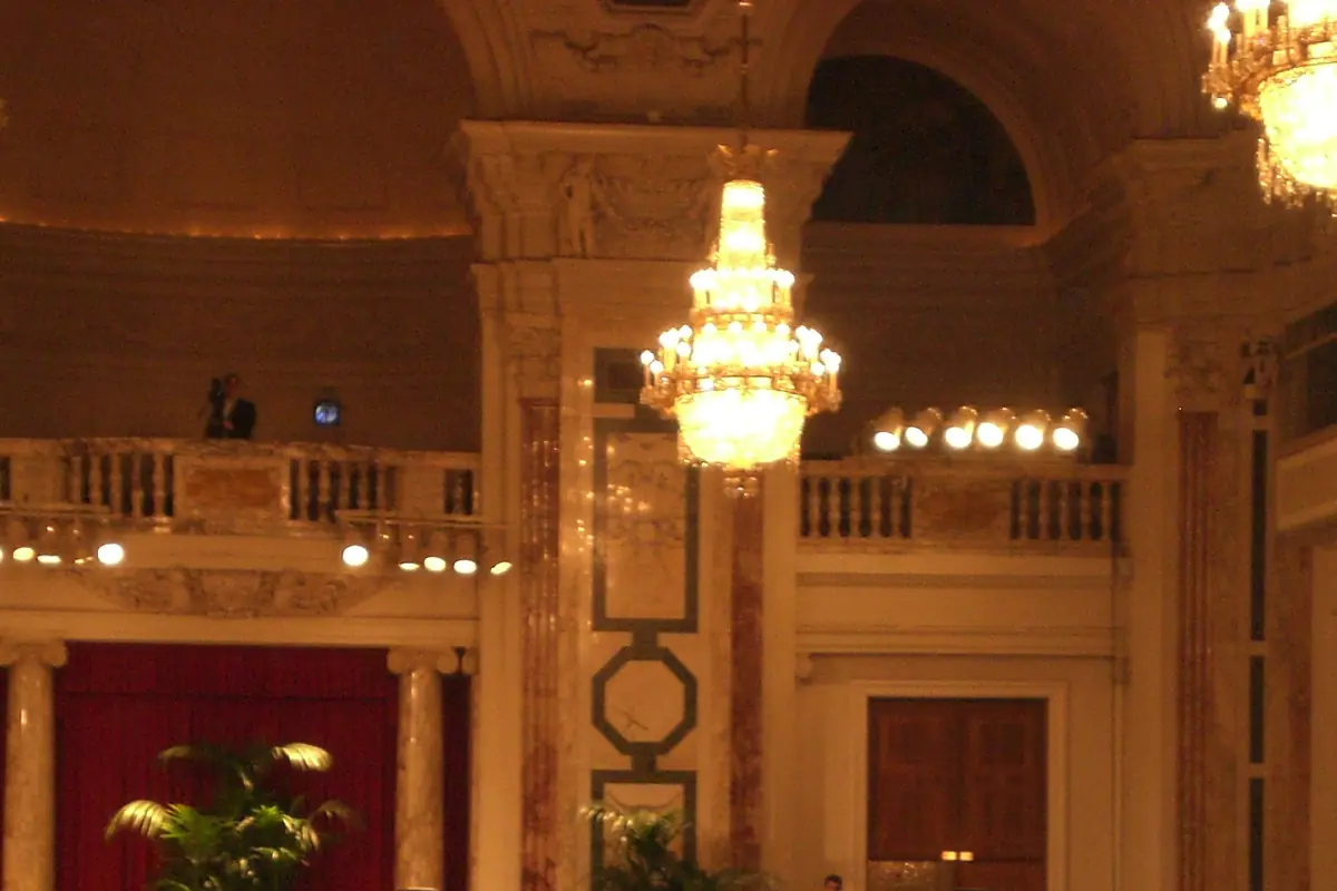 A palace hall with crystal chandeliers in warm evening light