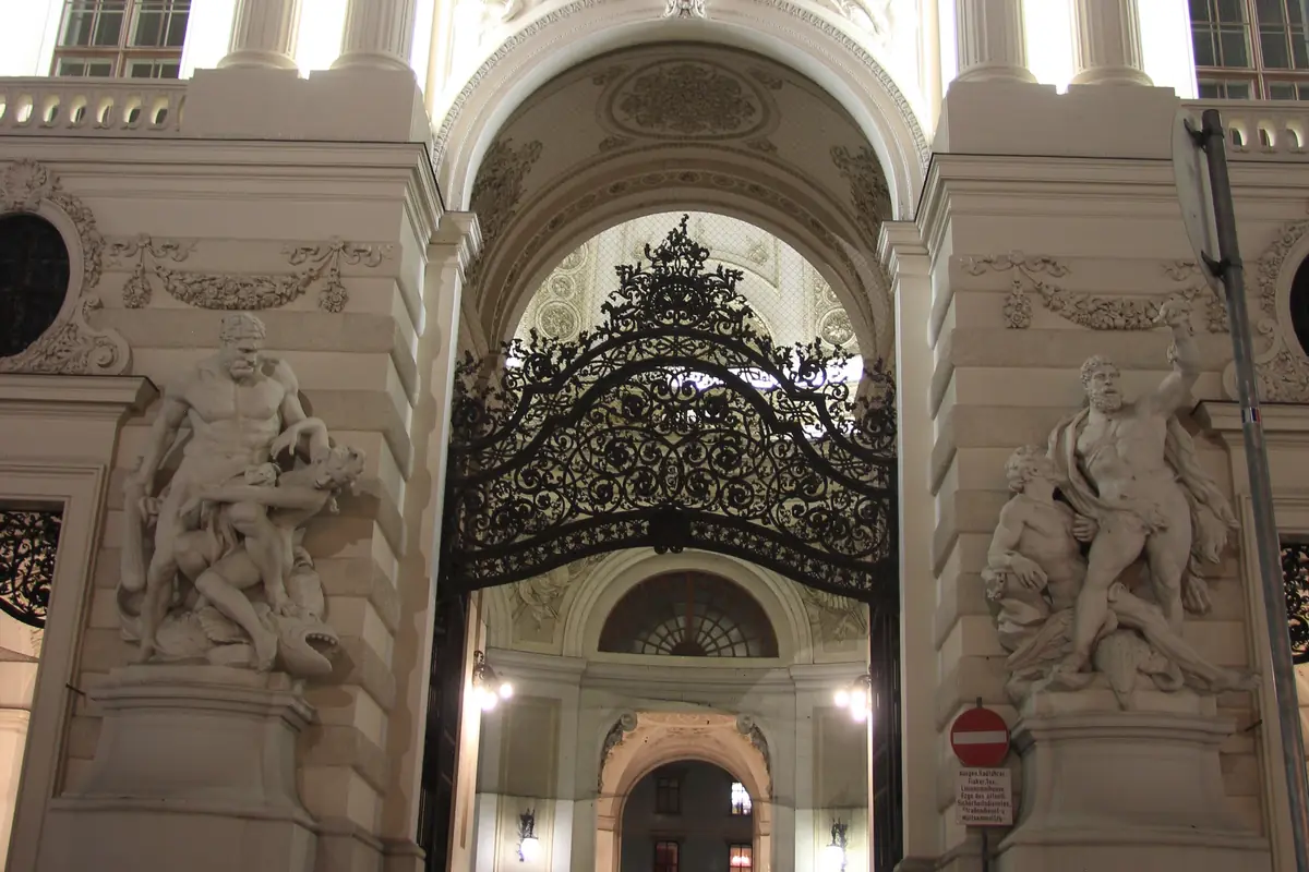 The wrought-iron gate of the Michaelertor in the Hofburg, lit at night